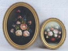 Two mid 20thC oil on canvas floral still life paintings in matched oval frames,