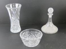 A large crystal glass vase in original box, together with a cut glass decanter and fruit bowl.