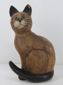 A carved and painted wooden figurine of a cat, one ear slightly a/f, 28cm high.