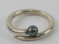 A black coloured pearl ring of wrap style, no apparent hallmarks, size Q.
