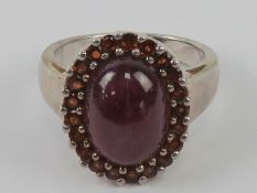A silver and red stone cluster ring, stamped 925, size P.