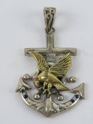 A large silver pendant in the form of an anchor with brass eagle upon,