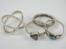 A silver 'X' shaped ring, stamped 925, size P, together with three other 925 silver rings .