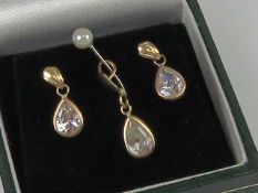 A suite of jewellery comprising earrings and pendant, white teardrop shaped stones,
