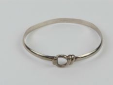 A HM silver bangle having knot and hook closure, approx 6.2 x 5.