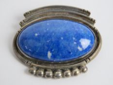 A sterling silver and blue hardstone brooch. 4.4cm wide.
