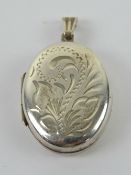 An oval silver HM locket having floral engraving to front, hallmarked for Birmingham, 3.