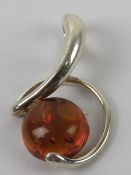 A silver and Baltic amber pendant having central round cabachon, stamped 925, 2.4cm in length.