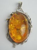 A large and impressive Baltic Amber pendant set in floral pendant, no apparent hallmarks,