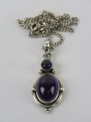A silver and double amethyst cabachon pendant, stamped 925 and measuring 4cm inc bale,