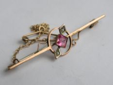 An Edwardian 9ct rose gold bar brooch set with square cut pink stone and seed pearls,