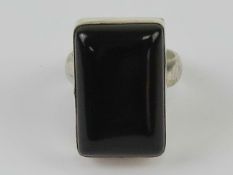 An onyx ring, the rectangular cabachon set in white metal stamped 925, size L-M.