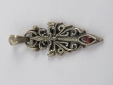 A white metal and red stone pendant of gothic form, stamped 925 and measuring 5cm in length.