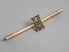An Edwardian 9ct gold bar brooch having seed pearl set 'H' design, stamped 9ct, 5.3cm wide, 2.3g.