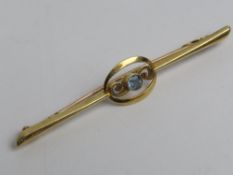 A 15ct gold Edwardian bar brooch having central aquamarine, stamped 15ct, 5.4cm in length, 1.8g.