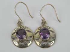 A pair of amethyst earrings, pierced scroll design, 4cm drop.