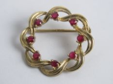 A 9ct gold wreath brooch set with rubies, hallmarked 375, 2.6cm dia, 3.3g.