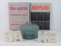 A quantity of decorative kitchen items including cake tin and chalk board signs.