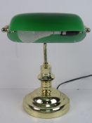 A brass 'bankers' lamp with green glass shade.