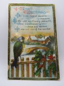 A vintage Christmas postcard featuring bird upon fence with snow covered bridge and building beyond,
