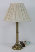 A single brass table lamp of column form, with shade.