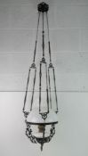A black painted ceiling pendant oil lamp with shade.