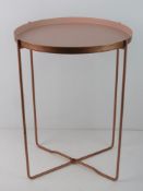 A rose metal and blush pink collapsible table.