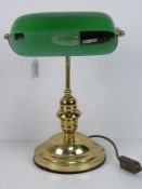 A brass 'bankers' lamp with green glass shade.