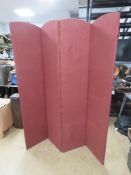 A four fold red fabric screen.