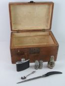A vintage wooden box containing a quantity of items including hip flask.