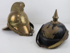 Reproduction items; a WWI German Pickelhaube helmet together with a brass Fireman's helmet.