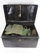A black metal trunk containing assorted militaria.