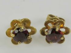 A pair of 9ct gold and garnet floral earrings, hallmarked 375, with butterfly backs, 1.7g.