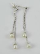 A pair of 18ct white gold and pearl earrings, stamped 750, 6cm drop, one buterfly back, 4.12g.