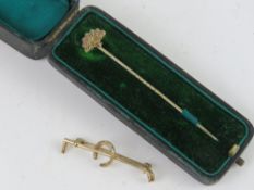 A yellow metal hunting brooch stock pin having horseshoe design.