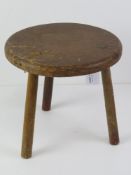 A three legged pine stool, 24cm dia.