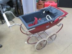 A Silver Cross dolls pram in red.