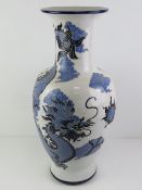 A large floor standing white ground vase having blue Chinese dragon design, 65cm high.