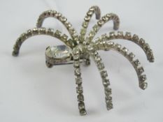 A large contemporary brooch in the form of a spider set with white stones, approx 7cm wide.
