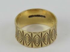 A 9ct gold ring, the band having star engraved pattern throughout, hallmarked 375, size O-P, 3.5g.