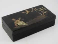 A Chine black lacquered pen box having gilt design with figure and bird upon, 15.5cm wide.