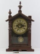 A vintage mantle clock having wooden case with glazed door, brass and paper dial.