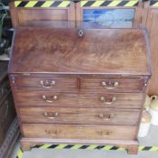 A late Georgian Walnut fall front bureau, lid lifting to reveal drawers and pigeonholes within,