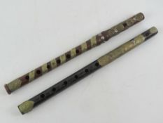 Two carved wooden recorder / whistle type musical instruments decorated with pressed metal 'leaves'