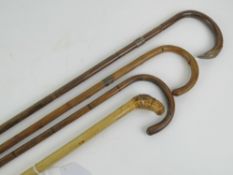 Four bamboo walking canes; one having sterling silver collar,