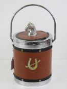 A c1970s ice bucket having leatherette cover with horses head handle and horseshoe design to front.