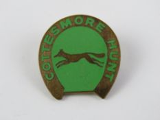 A Cottesmore Hunt badge in brass and green enamel.
