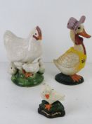 A Mother Goose cast iron contemporary door stops together with a small duck and a ceramic chicken