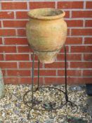 A terracotta urn shaped planter in iron frame, 76cm high.