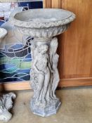A pre-cast birdbath raised over classical style females, 83cm high.